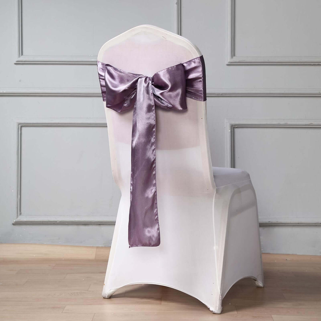 Elegant white chair with a lavender satin bow on the back.