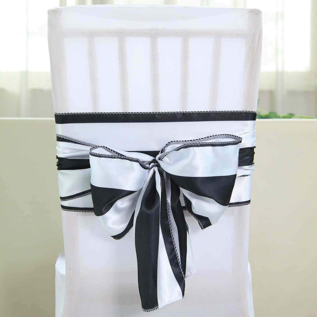Black and white chair sash bow on a white chair.