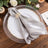 Elegant silver striped napkin with a decorative ring on a plate.
