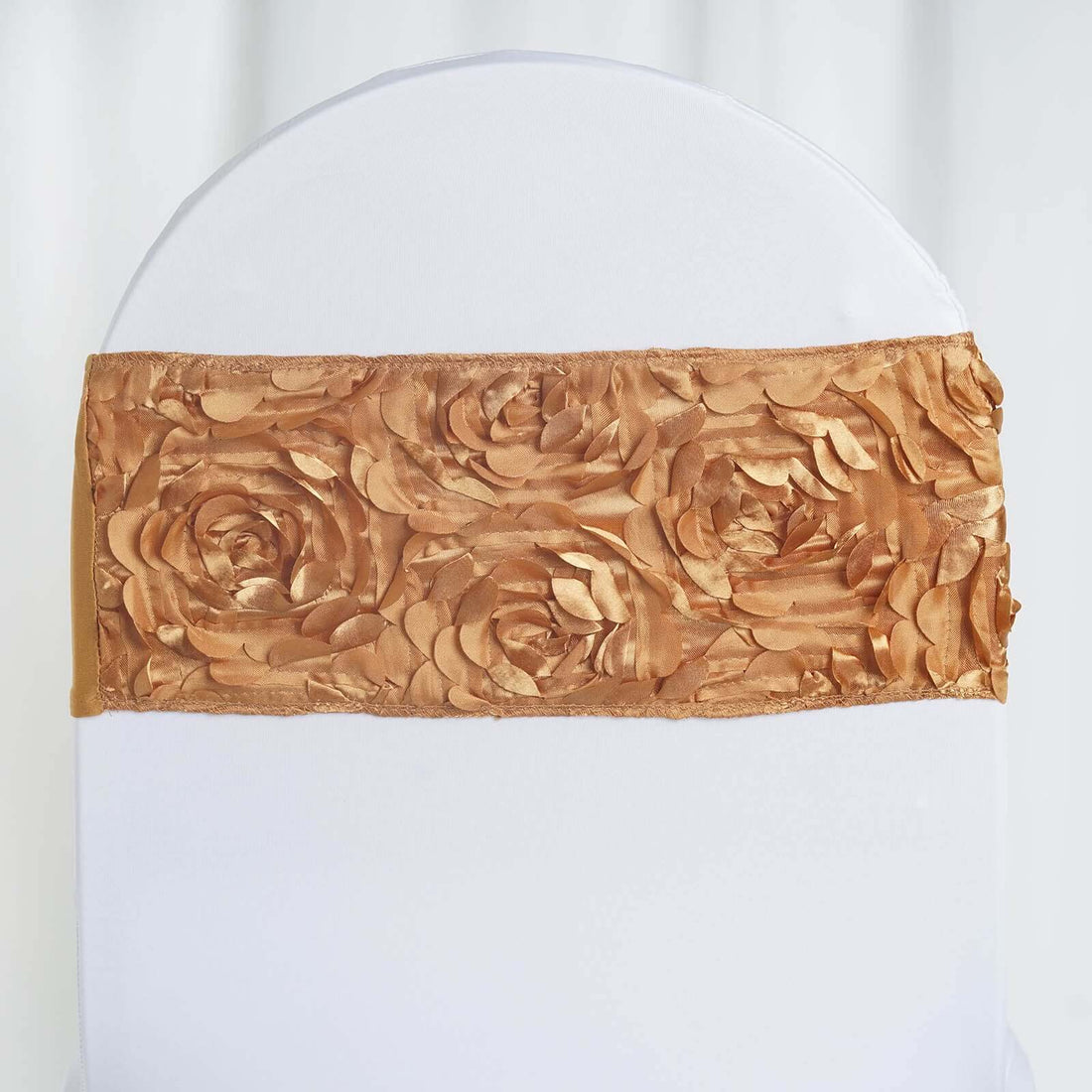 Gold rose-patterned chair sash on a white chair cover.