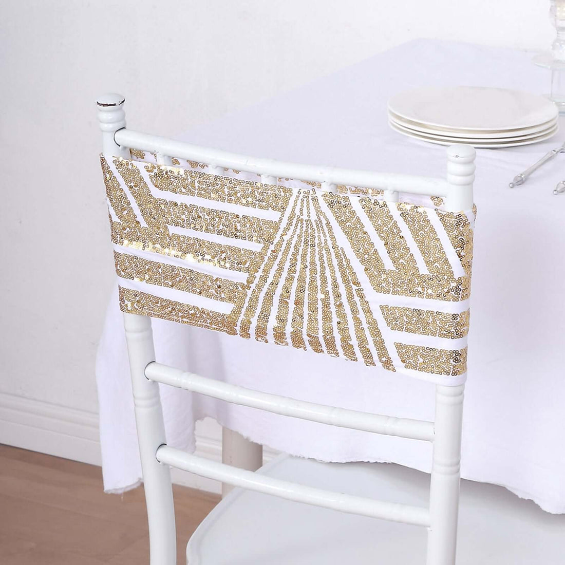 Gold-patterned chair back cover on a white chair against a plain backdrop.