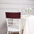 Burgundy sequined chair cover on a white dining chair with a table setting.
