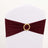 Maroon chair sash with gold ring detail on a plain white backdrop