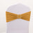Gold chair sash with a decorative beaded buckle on a white chair.