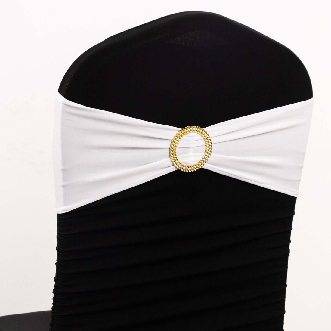 White chair sash with gold buckle on black chair cover