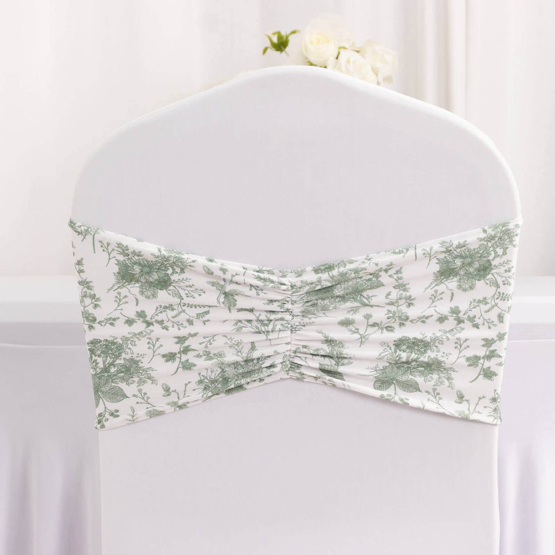 Floral chair cover with gathered design for elegant event decor.