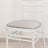 White chair with a padded gray seat on a neutral floor.