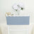 Gray chair cover on a white chiavari chair with a floral backdrop.