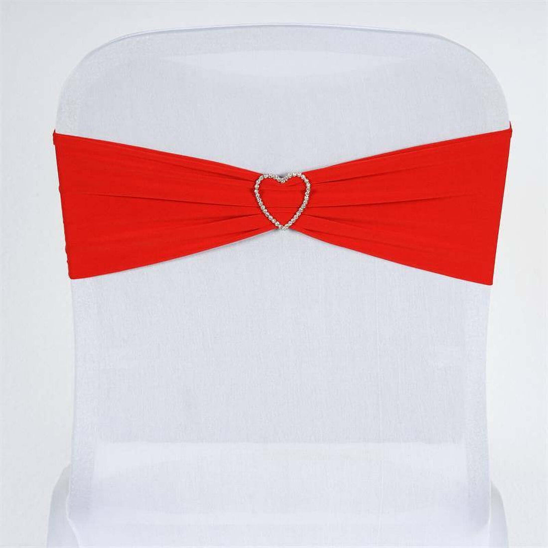 Red chair sash with rhinestone heart embellishment on a white chair.