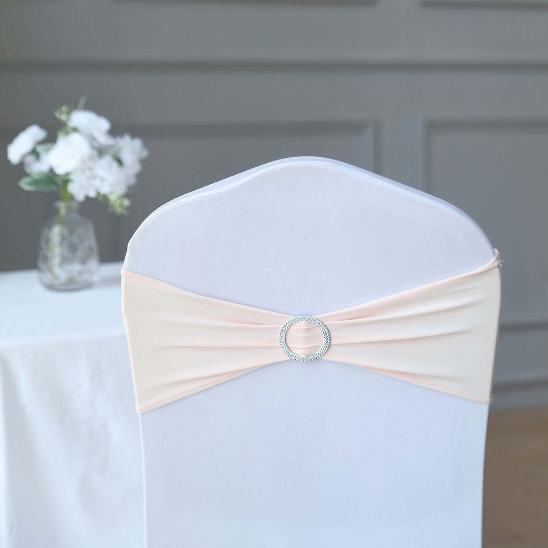 Peach chair cover with rhinestone buckle, elegantly draped for events