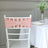 Pink chair sash with a decorative buckle on a white Chiavari chair.
