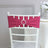 Pink chair sash with rhinestone embellishment on a white chiavari chair.
