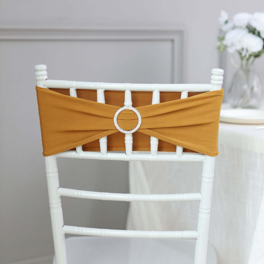 Mustard chair sash with rhinestone accent on a white chiavari chair.