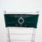 Green chair sash with rhinestone buckle on a clear chiavari chair.