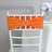 Orange chair sash with rhinestone buckle on a white chiavari chair.