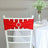 Red chair sash with rhinestone buckle on a white chair in a decorated setting.