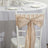 Elegant beige chair sash tied in a bow on a white chair at a dining table.