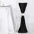 Black chair sash with white rose decoration on a white chair.
