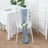 Elegant blue chair sash with a rose decoration on a white chair.