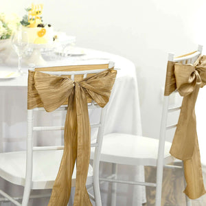Gold satin chair sashes tied in bows for elegant event decor.