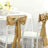 Gold satin chair sashes tied in bows for elegant event decor.