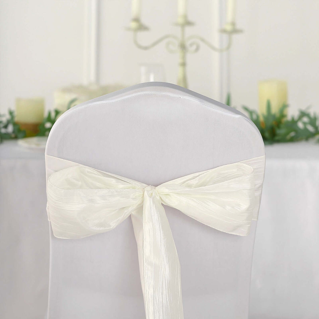 White chair cover with elegant ribbon bow, perfect for weddings and events.