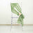 Green chair sash with a rose detail, elegantly draped on a clear chair.