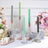 Elegant candle holders with colorful candles and floral arrangement in a styled setting.