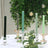 Elegant candle holders with colorful candles in a floral setting.