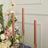 Elegant pink taper candles in gold holders, surrounded by floral arrangements.