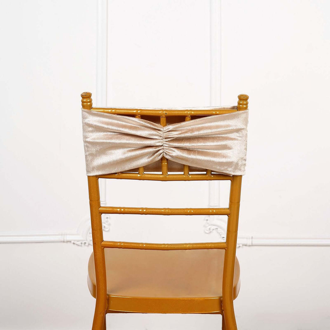 Gold satin chair sash tied at the back of a wooden chair