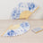 Blue floral design folding fans on a light wooden surface.