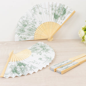 Decorative floral hand fans with bamboo handles on a light wooden surface.