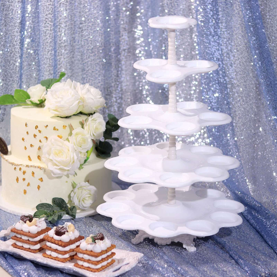 White tiered dessert stand with pastries and a cake on a glittery background.
