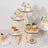 Wooden cupcake stand displaying various decorated cupcakes and desserts.
