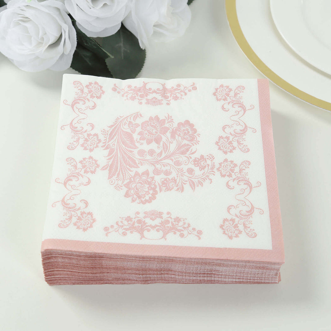 Pink floral decorative napkins stacked on a plain background.