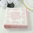 Pink floral decorative napkins stacked on a plain background.