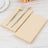 Beige dinner napkins with fork and knife on a wooden table.