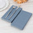 Blue napkins with a fork and knife on a wooden surface.