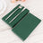 Green paper napkins with a fork and knife on a light wooden table.