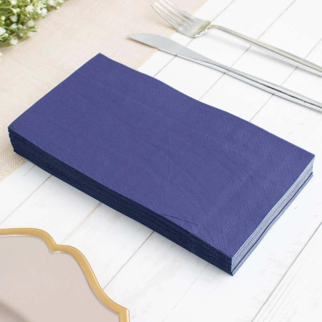 Stack of navy blue paper napkins on a table setting.