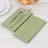 Green paper napkins with silver fork and knife on a wooden table.