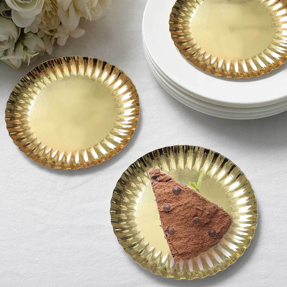 Gold foil dessert plates with a slice of chocolate cake.