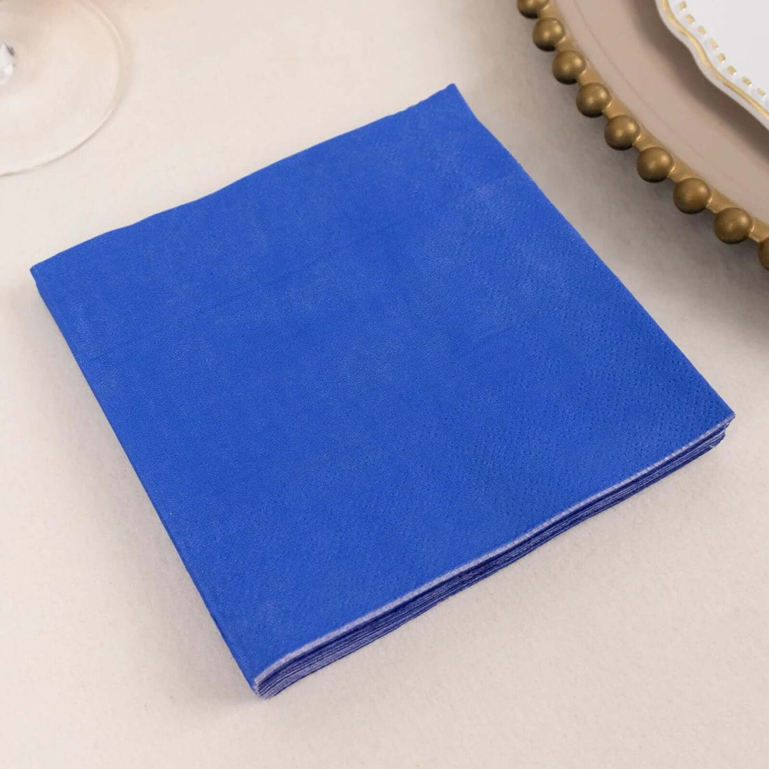 Blue paper napkins stacked neatly on a table.