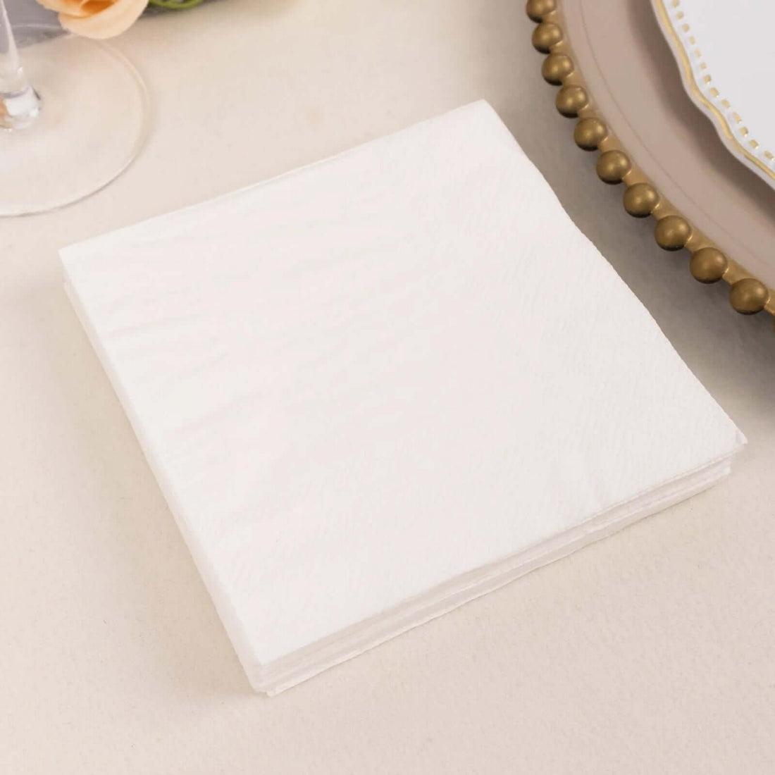 White disposable napkins stacked neatly on a table.