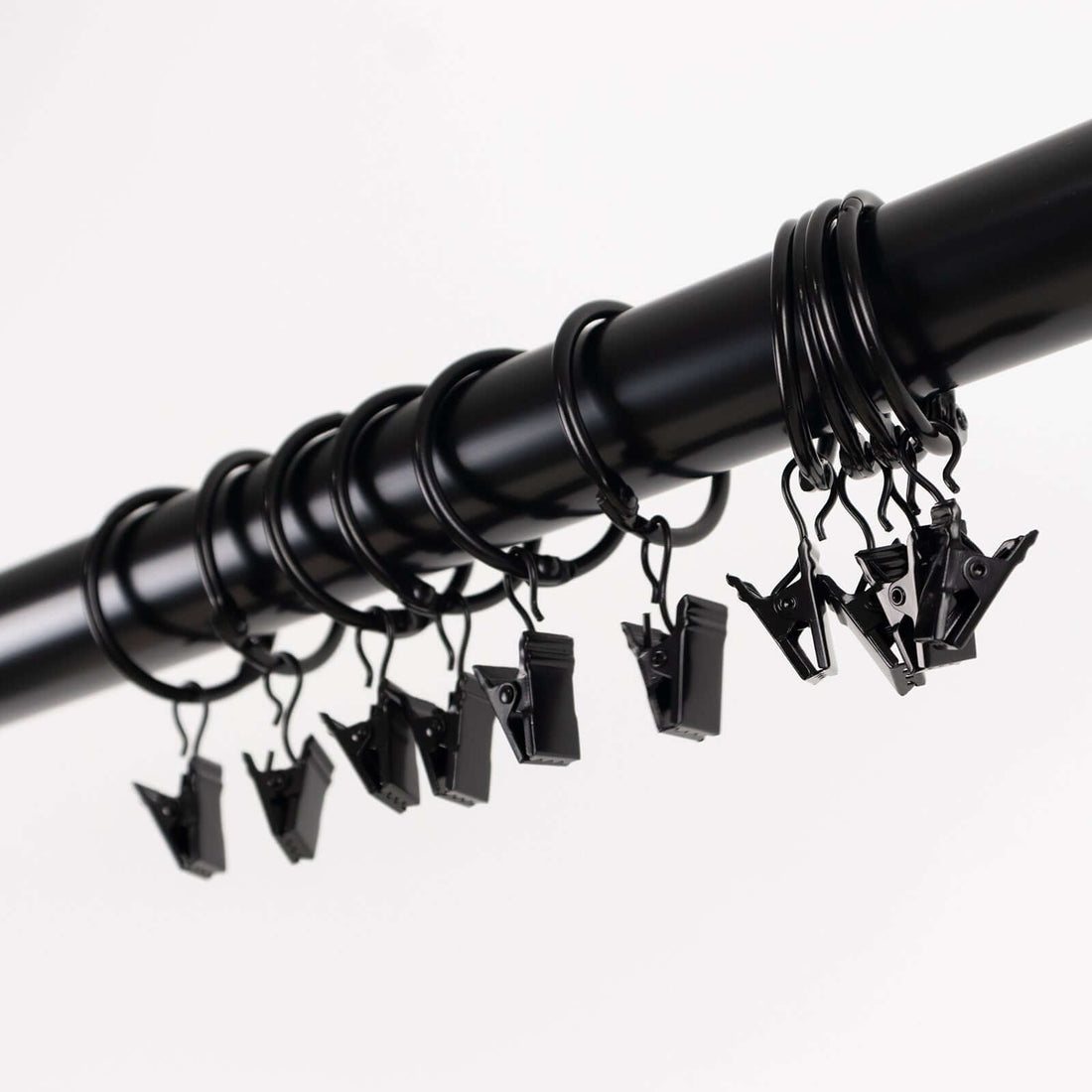 Black curtain clips hanging on a rod