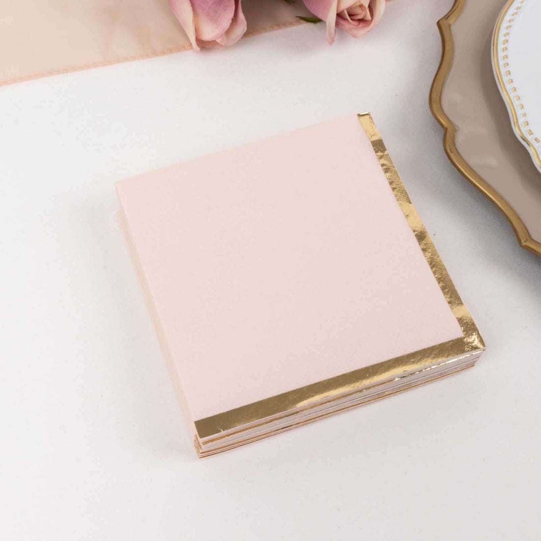 Pink notepad with gold foil edges on a white background