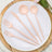 Pink biodegradable cutlery set on a white plate with a wooden background.