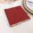 Red napkins with gold trim on a dining table setting.