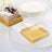 Gold-accented dessert containers on elegant plates with cake.